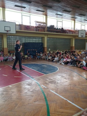 Policjant z dziećmi podczas pogadanki w szkole nt. bezpiecznych wakacji