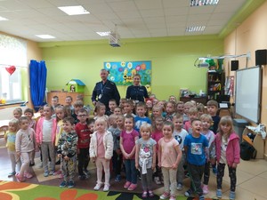 Policjant z dziećmi podczas pogadanki w szkole nt. bezpiecznych wakacji