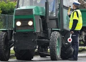 Policjant kontrolujący ciągnik rolniczy na drodze