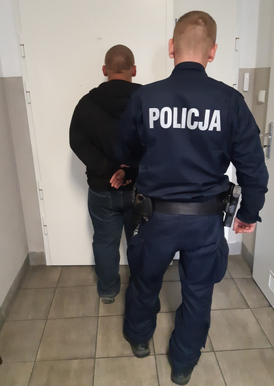 Policjant z zatrzymanym przed policyjnym aresztem