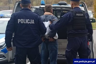 Podejrzany o zabójstwo prowadzony przez policjantów