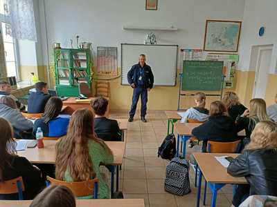 Policjantka rozmawiająca z młodzieżą o przestępstwach popełnianych na tle nienawiści