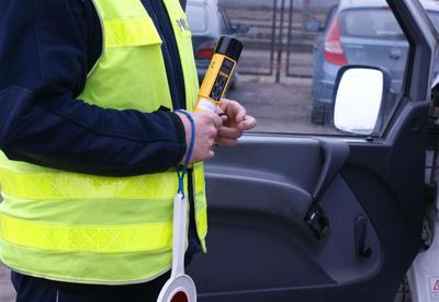 Policjant kontroluje pojazd i bada stan trzeźwości kierującego