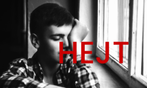 Siedzący nastolatek, na zdjęciu napis "hejt"