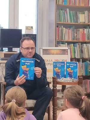 Kierownik PP w Dubeninkach czyta książkę dzieciom