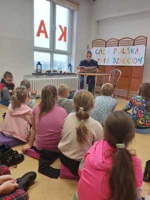 Dzielnicowa gminy Banie Mazurskie czyta dzieciom książkę w Bibliotece Publicznej w Baniach Mazurskich