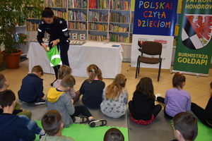 Policjantka rozdaje dzieciom doblaski podczas akcji &amp;quot;Cała Polska Czyta Dzieciom&amp;quot; w Bibliotece Publicznej w Gołdapi