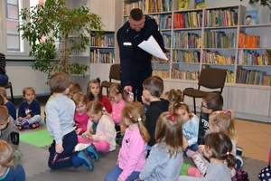 Policjant wręcza dzieciom odblaski w Bibliotece Publicznej w Gołdapi