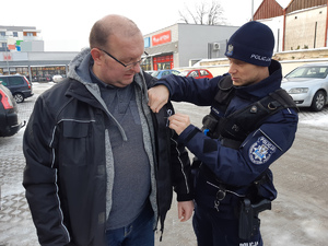 Policjanci przyczepiają &quot;Białą Wstążkę&quot; do odzieży mieszkańców powiatu gołdapskiego