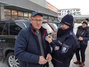 Policjanci przyczepiają &quot;Białą Wstążkę&quot; do odzieży mieszkańców powiatu gołdapskiego