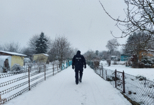 Policjant patroluje ogródki działkowe zimą